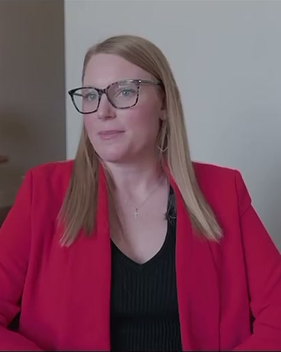 Colleen Butler in a red blazer, seated in her West Monroe office